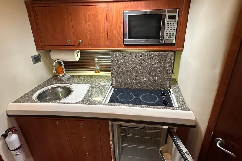 Slide: The Image of 2009 Monterey 350 Sport Yacht kitchen with sink, stove, microwave, and fridge. - 24