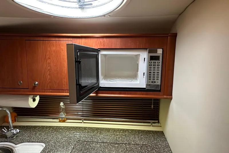 Slide: The Image of Microwave in 2009 Monterey 350 Sport Yacht kitchen with wooden cabinets and granite countertop. - 25