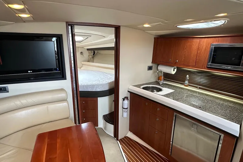 Slide: The Image of Interior of 2009 Monterey 350 Sport Yacht with kitchenette, seating, and sleeping area. - 32