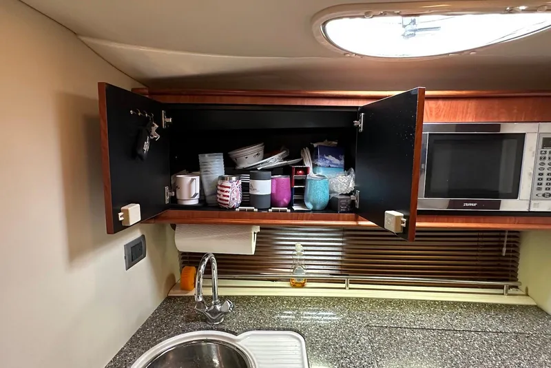 Slide: The Image of 2009 Monterey 350 Sport Yacht kitchen with open cabinet, microwave, and sink. - 34