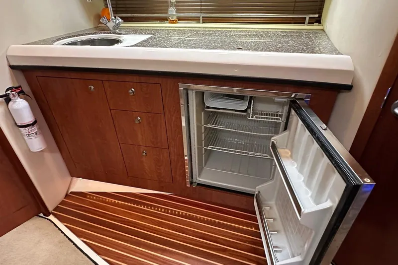 Slide: The Image of 2009 Monterey 350 Sport Yacht kitchen with open fridge, sink, and wooden cabinetry. - 42