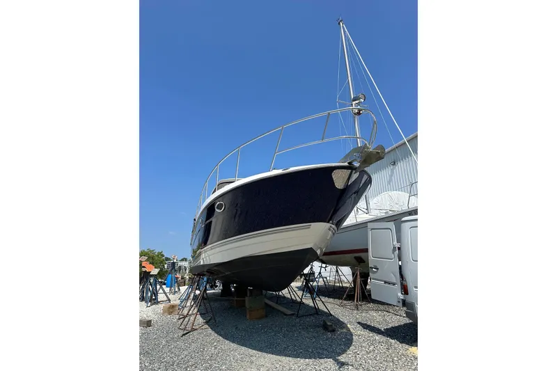 Slide: The Image of 2009 Monterey 350 Sport Yacht on stands, blue hull, clear sky background. - 6