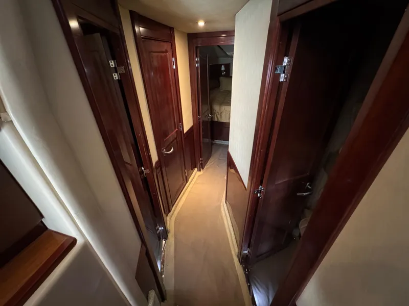 Slide: The Image of Hallway inside 2007 Sea Ray 52 Sedan Bridge yacht with wooden doors and beige walls. - 34
