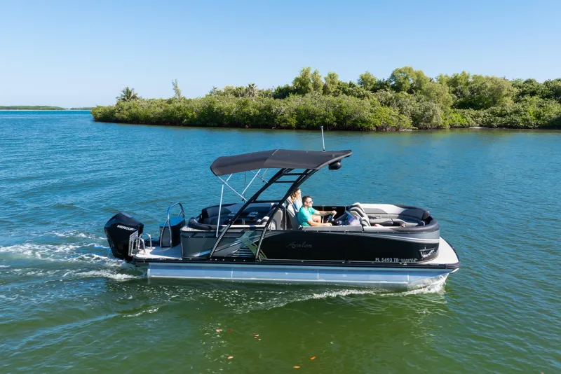 Slide: The Image of 2021 Avalon LSZ Quad Lounger 24' pontoon boat cruising on a scenic lake. - 5