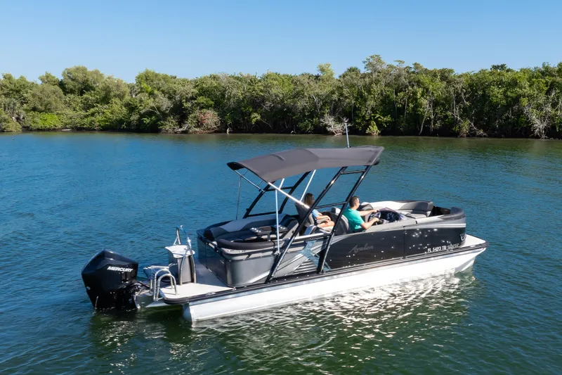 Slide: The Image of 2021 Avalon LSZ Quad Lounger boat cruising on a serene lake with lush greenery. - 7