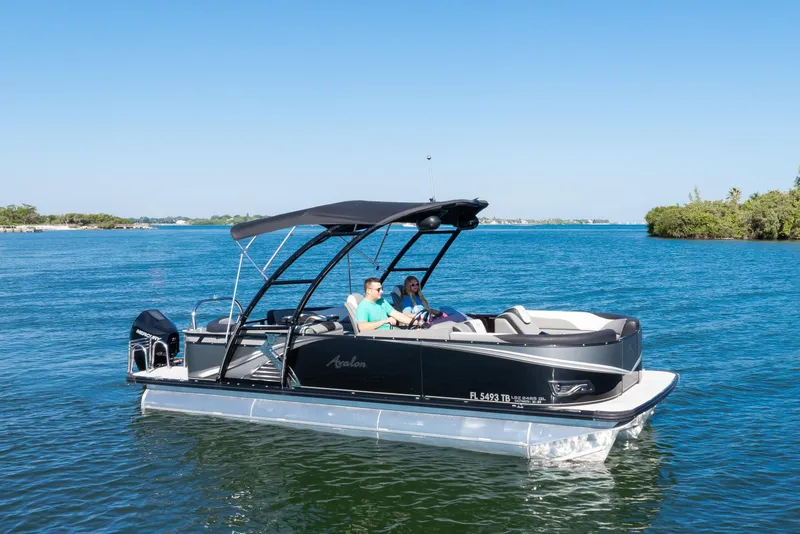 Slide: The Image of 2021 Avalon LSZ Quad Lounger 24' pontoon boat cruising on a sunny lake. - 9