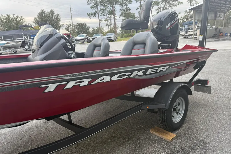 Slide: The Image of 2003 Bass Tracker PT175 boat on trailer, featuring red exterior and Mercury engine. - 2
