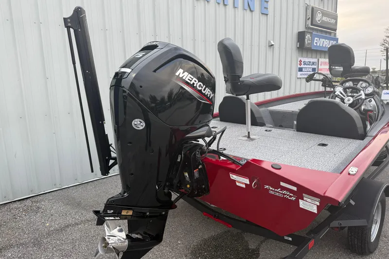Slide: The Image of 2003 Bass Tracker PT175 boat with Mercury outboard motor, parked near a marine dealership. - 3