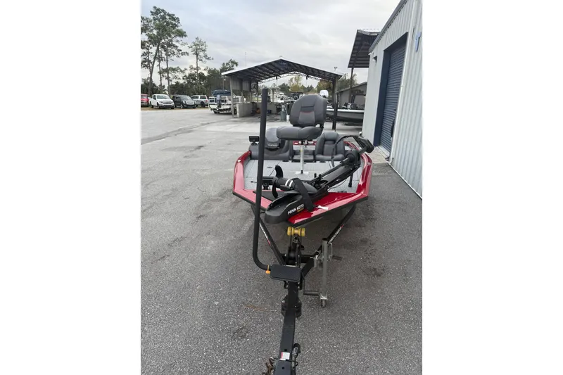 Slide: The Image of 2003 Bass Tracker PT175 boat on trailer, parked outdoors near storage facility. - 5