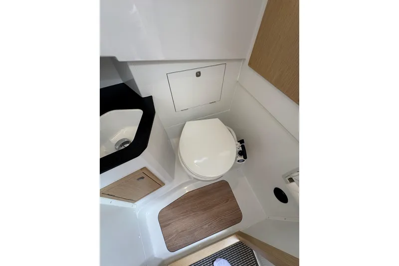 Slide: The Image of 2025 Sargo 28 boat bathroom with toilet, sink, and wooden accents. - 19