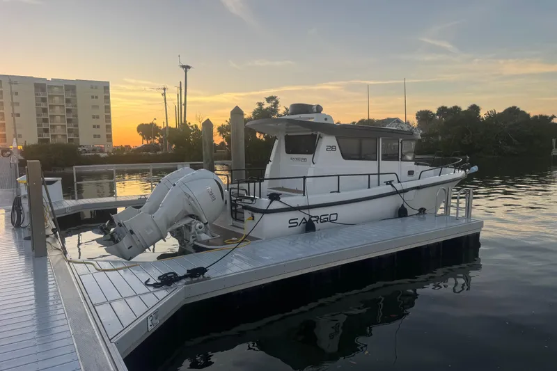 Slide: The Image of 2025 Sargo 28 boat docked at sunset. - 2