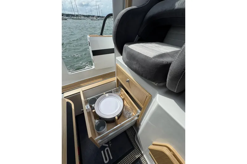 Slide: The Image of 2025 Sargo 28 interior with open drawer, showcasing tableware and seating. - 20