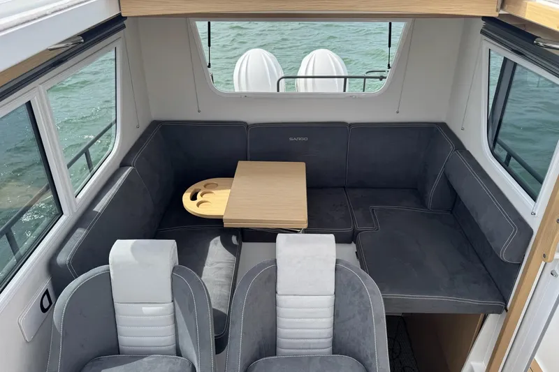 Slide: The Image of Interior of 2025 Sargo 28 boat with gray seating and wooden table. - 22