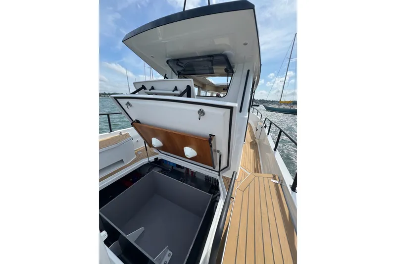 Slide: The Image of 2025 Sargo 28 boat with open storage compartment on deck, docked by the water. - 26