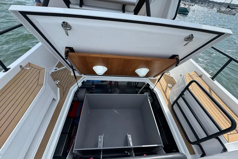 Slide: The Image of Open storage compartment on 2025 Sargo 28 boat with wooden deck details. - 27