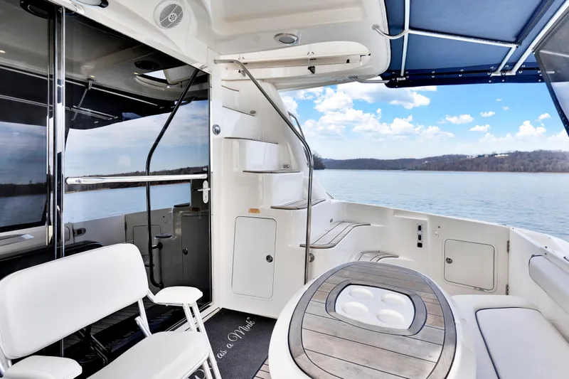 Slide: The Image of 2006 Sea Ray 58 Sedan Bridge yacht interior with seating, table, and scenic water view. - 10