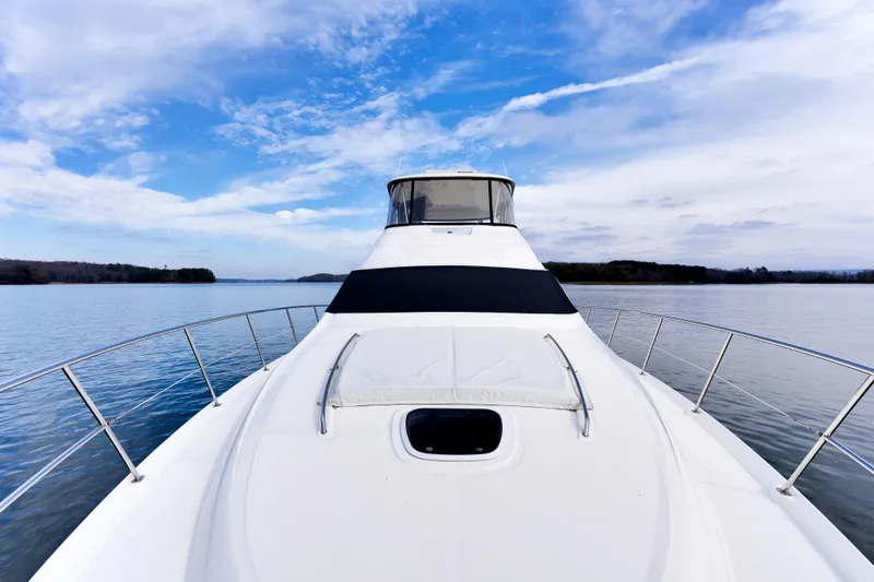 Slide: The Image of 2006 Sea Ray 58 Sedan Bridge yacht on calm water under blue sky. - 11