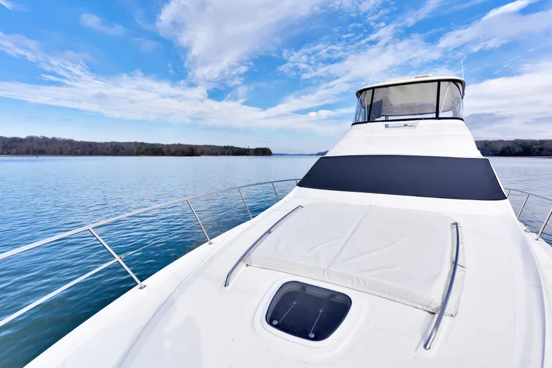 Slide: The Image of 2006 Sea Ray 58 Sedan Bridge yacht on calm water under a blue sky. - 12