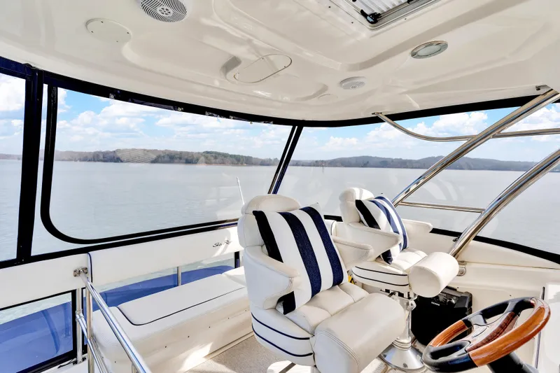 Slide: The Image of Interior view of 2006 Sea Ray 58 Sedan Bridge yacht with plush seating and scenic water backdrop. - 15