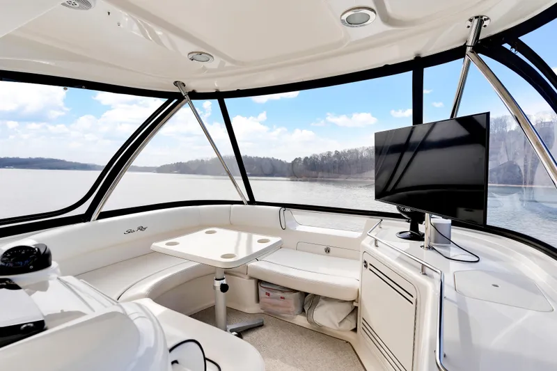 Slide: The Image of Interior of 2006 Sea Ray 58 Sedan Bridge yacht with seating and TV, overlooking serene water. - 17