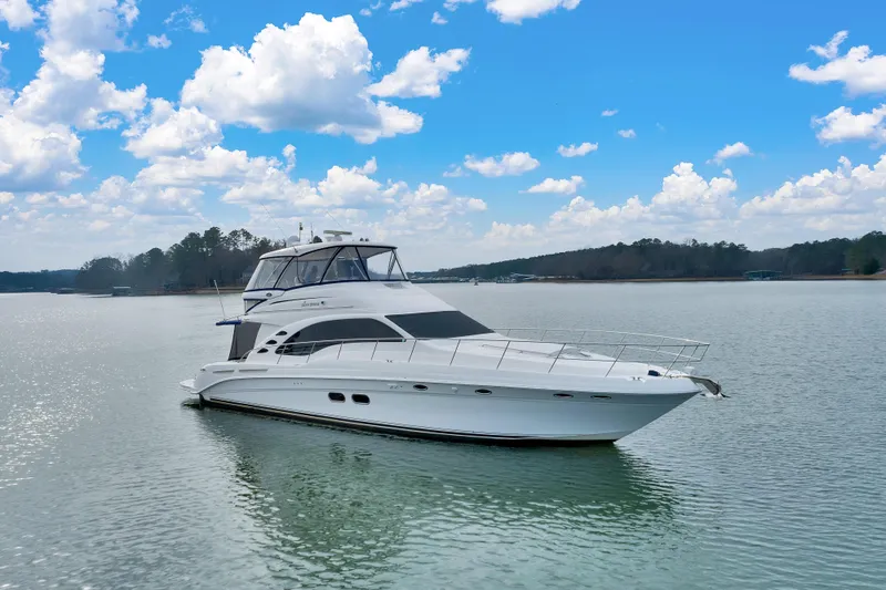 Slide: The Image of 2006 Sea Ray 58 Sedan Bridge yacht on calm water under a blue sky. - 2