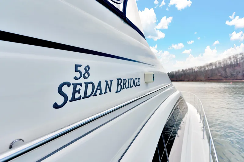 Slide: The Image of 2006 Sea Ray 58 Sedan Bridge yacht on water, showcasing sleek design and branding. - 42