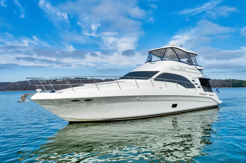 Slide: The Image of 2006 Sea Ray 58 Sedan Bridge yacht on calm water under a blue sky. - 7