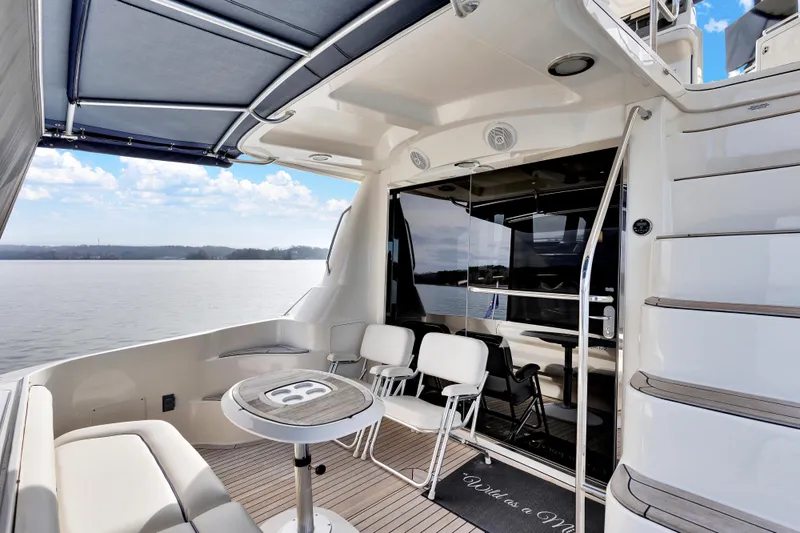 Slide: The Image of 2006 Sea Ray 58 Sedan Bridge yacht deck with seating and scenic water view. - 9