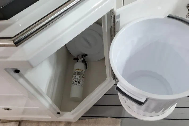 Slide: The Image of 2022 Formula 380 Super Sport Crossover OB storage compartment with fire extinguisher and trash bin. - 34