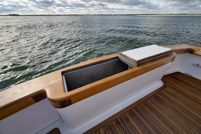 Slide: The Image of 2002 Paul Mann 60 Custom Carolina boat deck with open storage compartment, overlooking calm waters. - 53