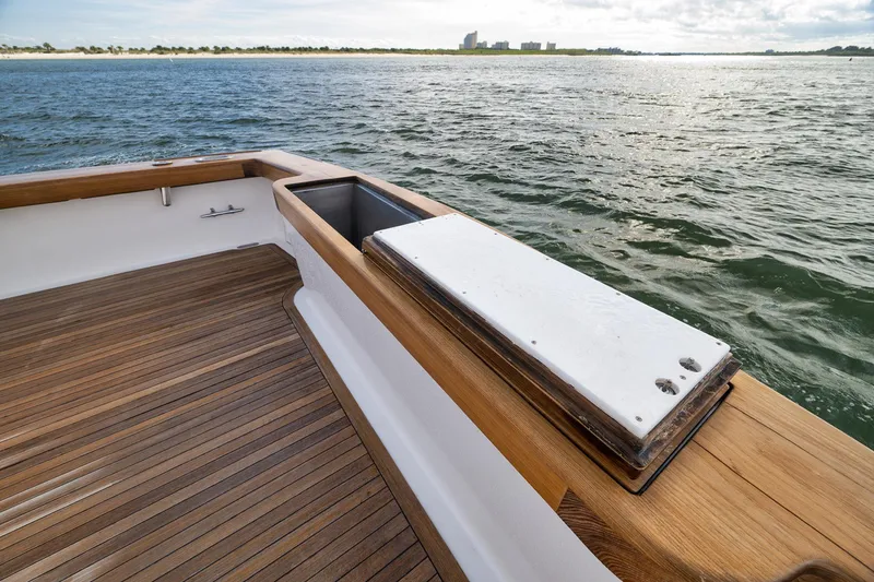 Slide: The Image of Paul Mann 60 Custom Carolina 2002 boat deck with wooden finish, overlooking calm waters. - 55