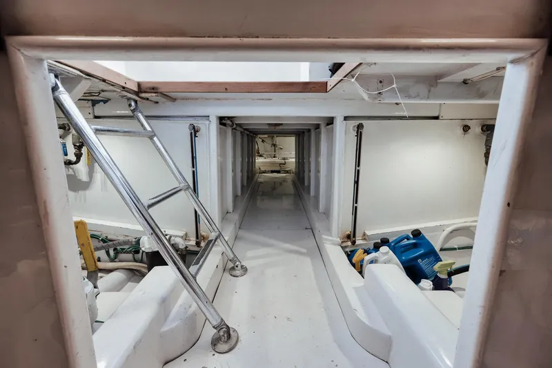 Slide: The Image of Engine room of 2002 Paul Mann 60 Custom Carolina boat, featuring ladder and equipment. - 67