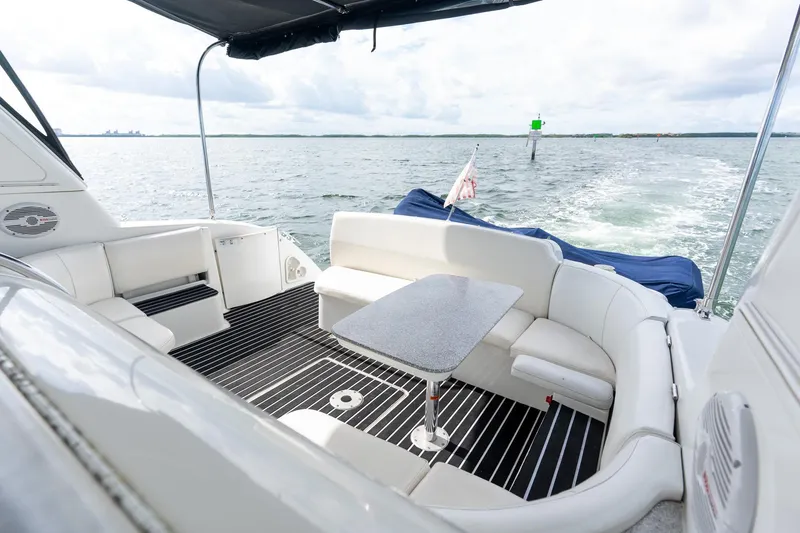 Slide: The Image of 2005 Formula 48 Yacht interior with white seating and table, overlooking calm waters. - 16