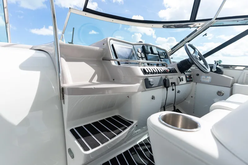 Slide: The Image of 2005 Formula 48 Yacht cockpit with steering wheel, controls, and cup holder under a clear sky. - 28