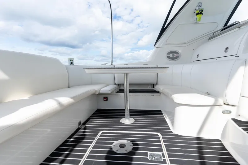 Slide: The Image of 2005 Formula 48 Yacht interior with white seating and sleek table under a cloudy sky. - 31