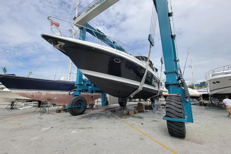 Slide: The Image of 2005 Formula 48 Yacht lifted by crane in a marina for maintenance. - 61