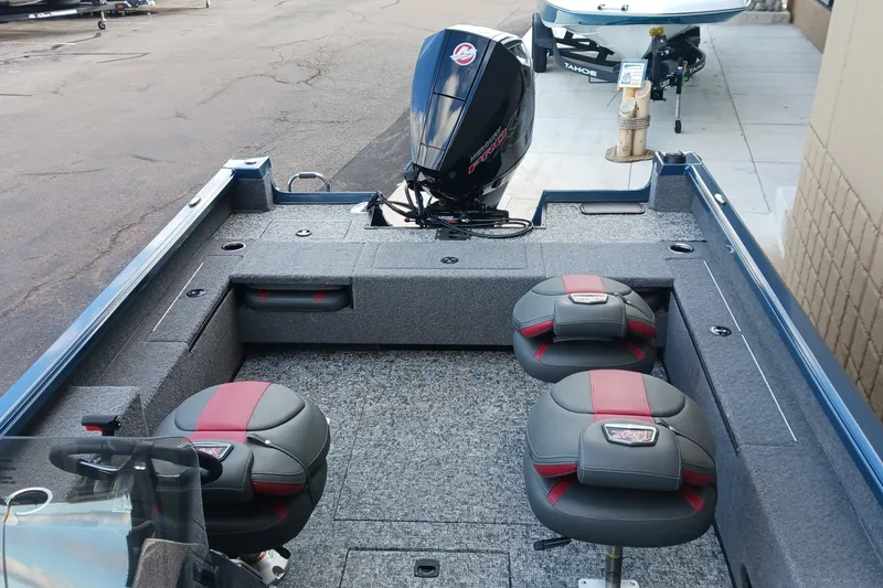 Slide: The Image of 2026 Ranger VS1882SC Reata boat interior with seating and motor, parked on pavement. - 7