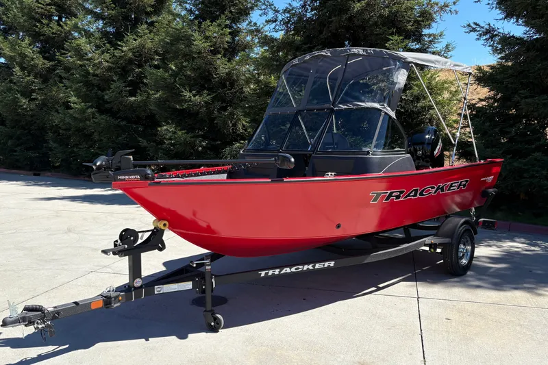 Slide: The Image of 2026 Tracker Pro Guide V-16 WT boat in vibrant red on a trailer, parked outdoors. - 7