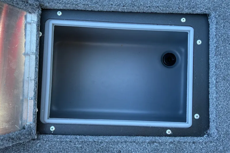 Slide: The Image of 2026 Tracker Pro Guide V-16 WT boat storage compartment with gray interior and secure lid. - 25