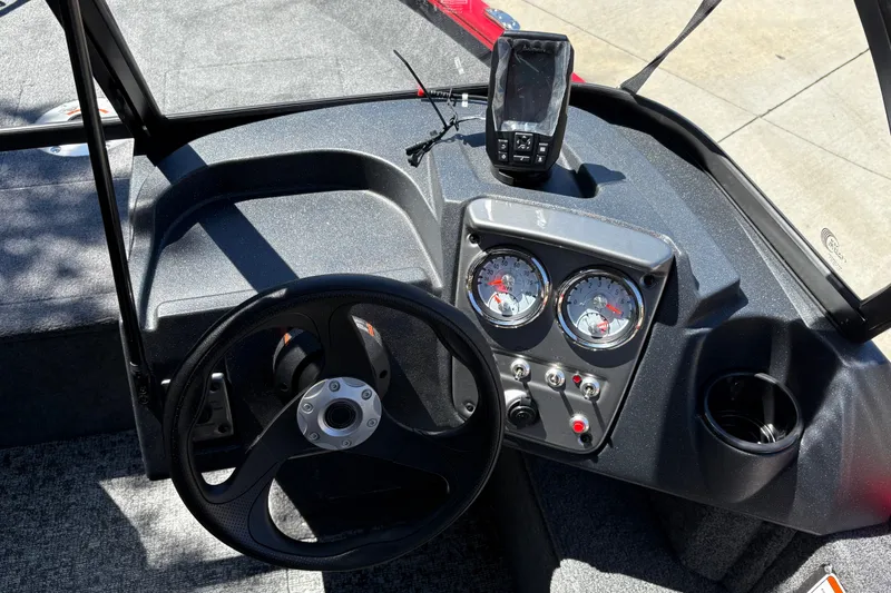 Slide: The Image of 2026 Tracker Pro Guide V-16 WT boat dashboard with steering wheel and gauges. - 18