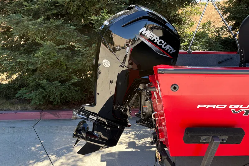 Slide: The Image of 2026 Tracker Pro Guide V-16 WT boat with Mercury outboard motor, parked outdoors. - 13