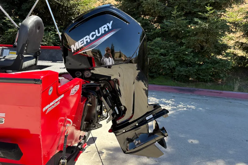 Slide: The Image of 2026 Tracker Pro Guide V-16 WT boat with Mercury outboard motor, parked outdoors. - 11