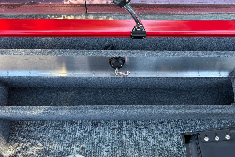 Slide: The Image of 2026 Tracker Pro Guide V-16 WT boat interior with red accents and carpeted storage compartment. - 32