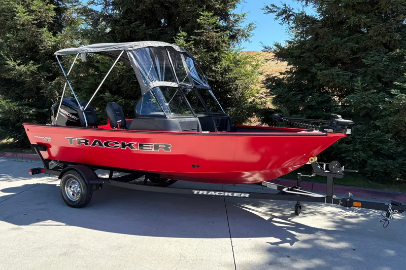 Slide: The Image of 2026 Tracker Pro Guide V-16 WT boat in vibrant red on trailer, parked outdoors. - 4