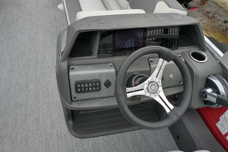 Slide: The Image of Steering console of 2026 Sun Tracker Fishin' Barge 22 DLX with modern controls. - 2