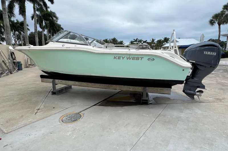Slide: The Image of 2022 Key West 239 DFS boat with Yamaha engine on a dock, surrounded by palm trees. - 10