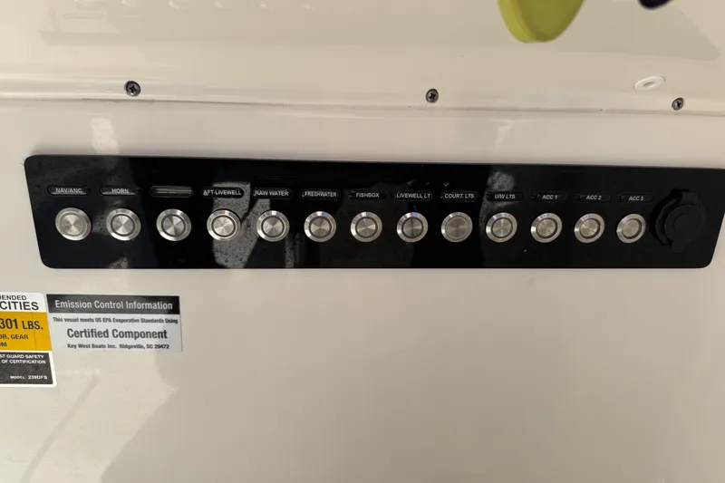Slide: The Image of Control panel of a 2022 Key West 239 DFS boat with labeled switches and emission information. - 24