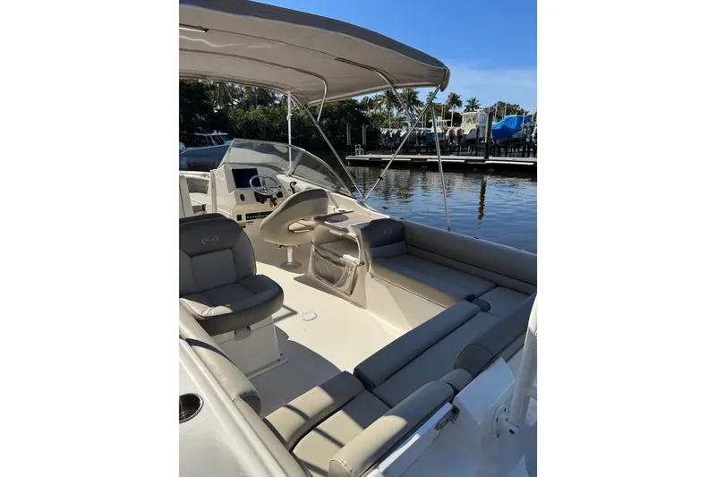Slide: The Image of 2022 Key West 239 DFS boat interior with seating and steering wheel, docked by water. - 8