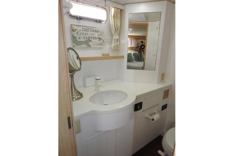 Slide: The Image of Bathroom interior of 1998 Ocean Alexander Yachtfish Command Bridge, featuring sink and mirror. - 12