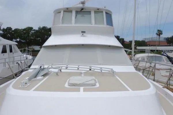 Slide: The Image of 1998 Ocean Alexander Yachtfish Command Bridge, docked, showcasing sleek design and spacious deck. - 24